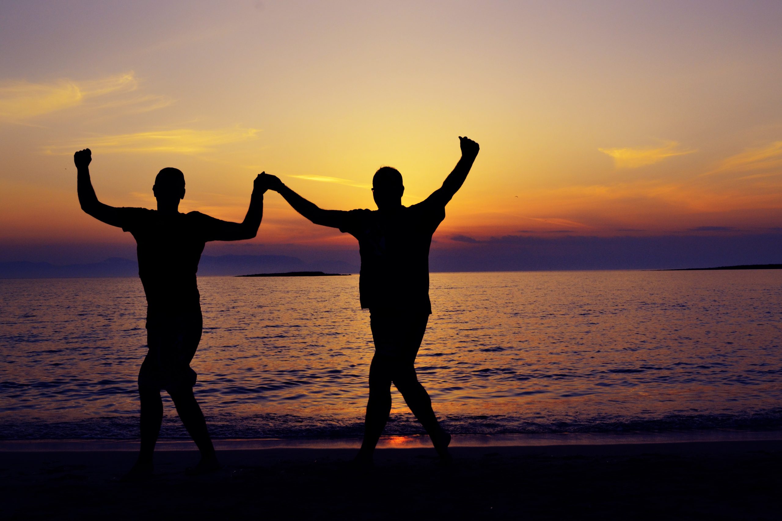 Twee figuren dansen aan zee